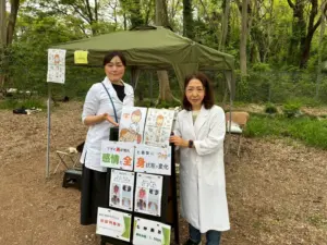 看板の前に立つ院長